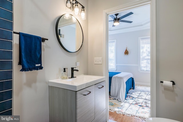 bathroom featuring a ceiling fan, connected bathroom, wood finished floors, crown molding, and vanity