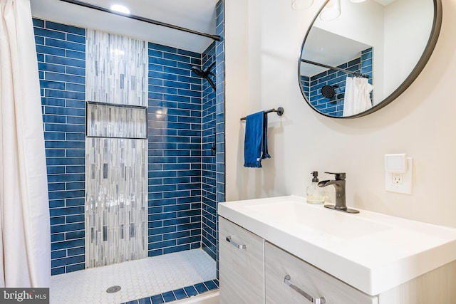 bathroom with a shower stall and vanity