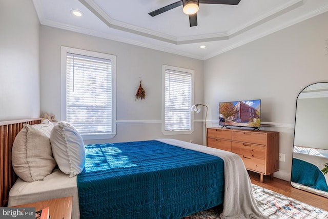 bedroom featuring multiple windows, a raised ceiling, and crown molding