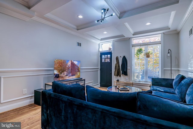 home theater with crown molding, light wood finished floors, visible vents, coffered ceiling, and beamed ceiling