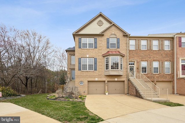 townhome / multi-family property featuring brick siding, an attached garage, and driveway