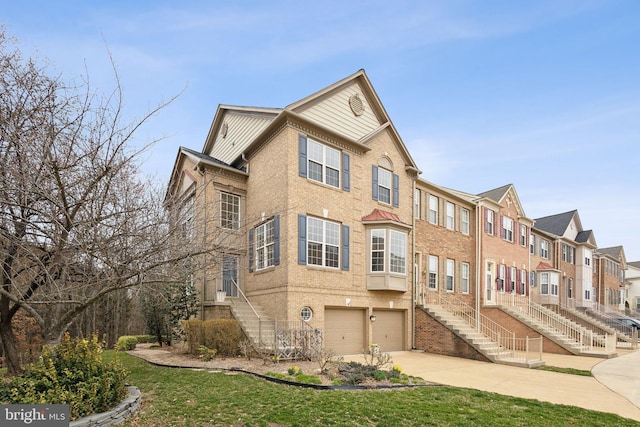 townhome / multi-family property featuring stairs, a garage, brick siding, and driveway