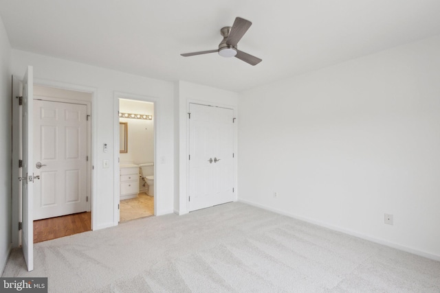 unfurnished bedroom featuring ceiling fan, baseboards, ensuite bathroom, and carpet