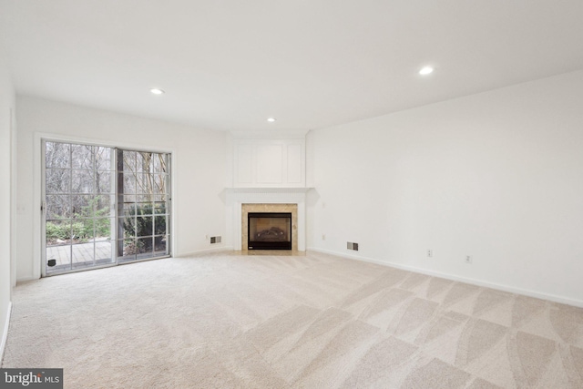 unfurnished living room featuring light carpet, recessed lighting, a large fireplace, and baseboards