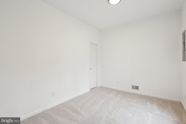 empty room featuring light carpet, visible vents, and baseboards