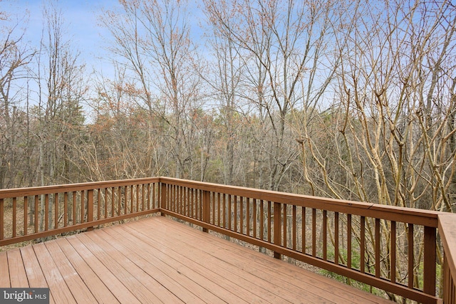 wooden terrace featuring a wooded view