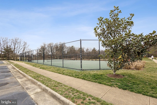 view of sport court with a yard and fence