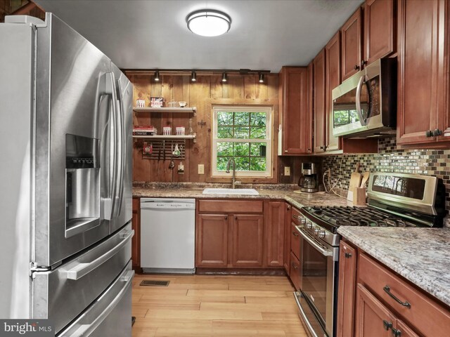 47 Timberline Dr, Lost River, WV 26810 - kitchen featuring appliances with stainless steel finishes, a sink, light wood-type flooring, rail lighting, and tasteful backsplash