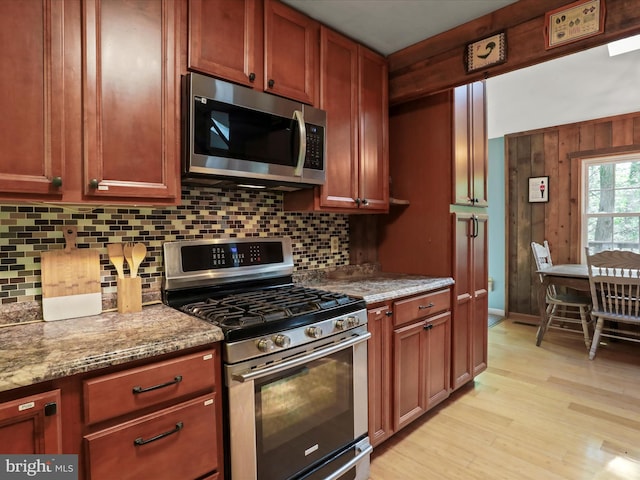 47 Timberline Dr, Lost River, WV 26810 - kitchen with stainless steel appliances, decorative backsplash, light wood-style flooring, light stone counters, and wood walls