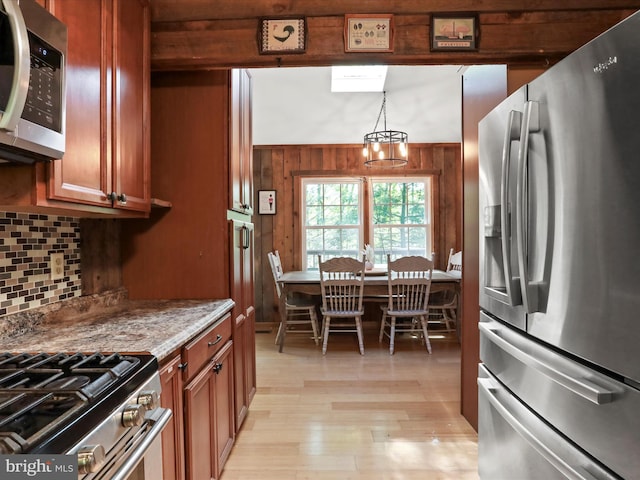 47 Timberline Dr, Lost River, WV 26810 - kitchen featuring stainless steel appliances, light wood-type flooring, tasteful backsplash, a chandelier, and wooden walls