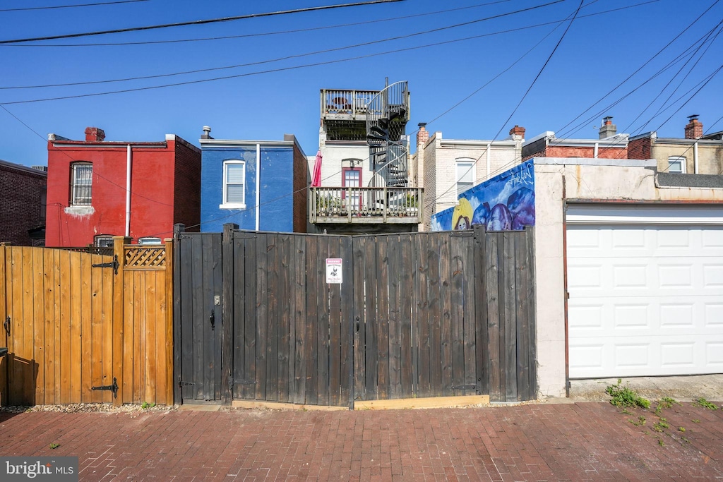 exterior space featuring a garage, fence, and a gate