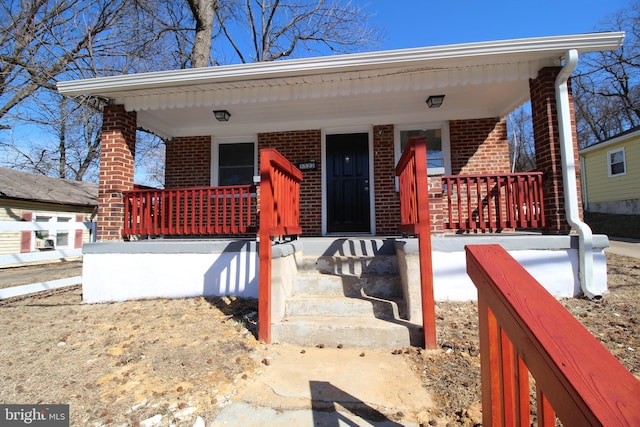 bungalow-style house with a porch and brick siding