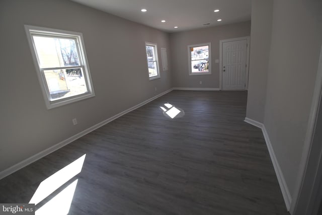 unfurnished room featuring dark wood-style floors, recessed lighting, a wealth of natural light, and baseboards