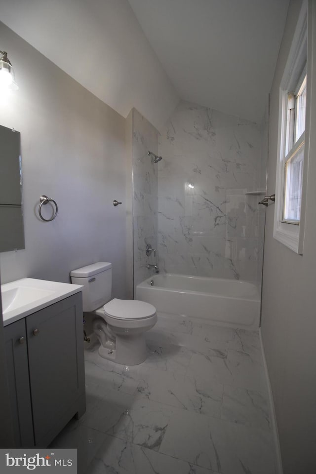 bathroom featuring lofted ceiling, toilet,  shower combination, marble finish floor, and vanity