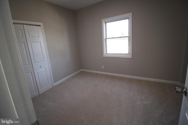 empty room with carpet and baseboards