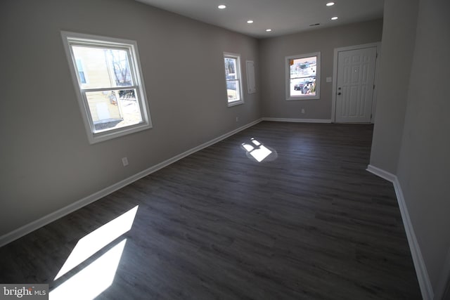 spare room with baseboards, dark wood finished floors, and recessed lighting