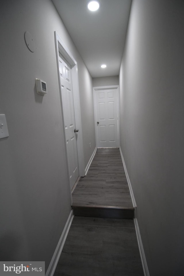 hall featuring recessed lighting, dark wood finished floors, and baseboards