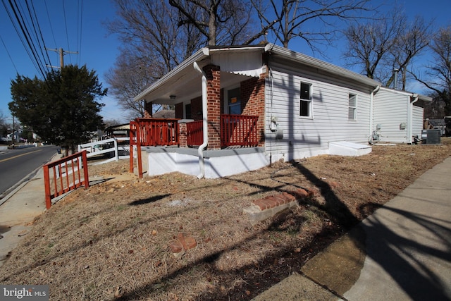 view of side of home with brick siding and a porch