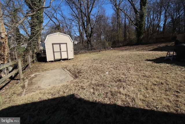 view of yard with a storage shed, fence, and an outdoor structure