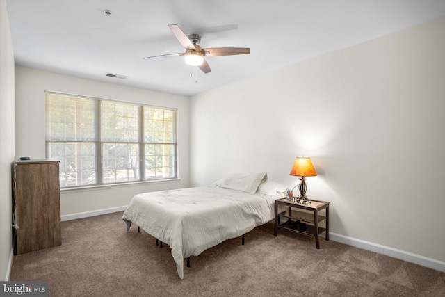 carpeted bedroom featuring ceiling fan, visible vents, and baseboards