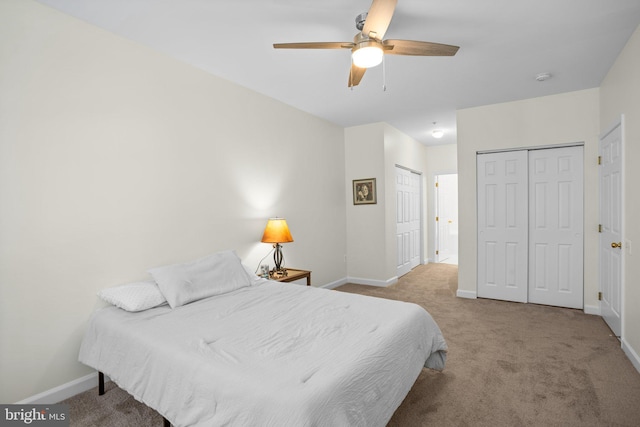 bedroom featuring carpet floors, multiple closets, a ceiling fan, and baseboards