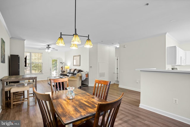 dining space with dark wood-style floors, ornamental molding, visible vents, and baseboards