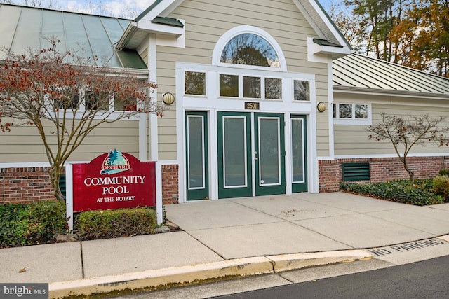 property entrance with a standing seam roof, metal roof, and brick siding