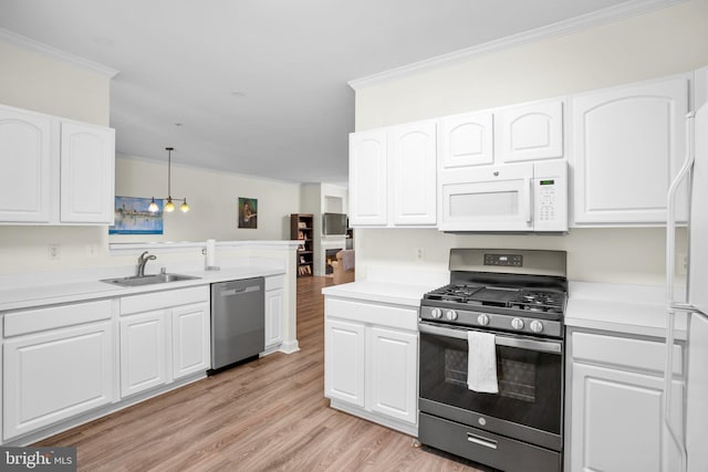 kitchen featuring crown molding, light wood-style flooring, appliances with stainless steel finishes, white cabinets, and a sink