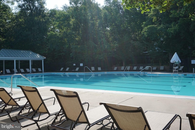 community pool with a patio and fence