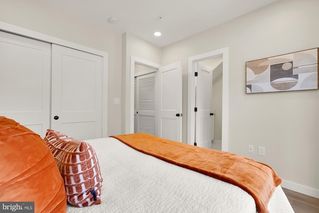 bedroom featuring a closet, baseboards, wood finished floors, and recessed lighting