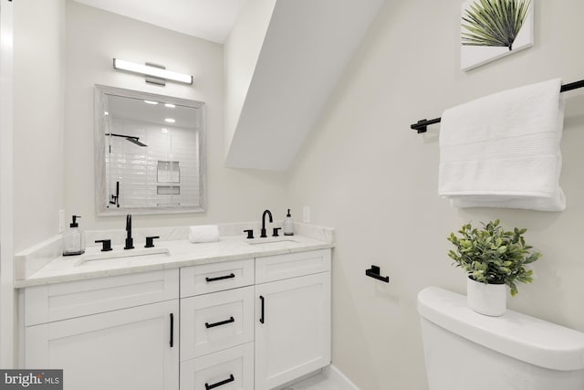 bathroom featuring double vanity, a shower stall, toilet, and a sink