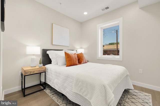 bedroom with baseboards, recessed lighting, visible vents, and light wood-style floors