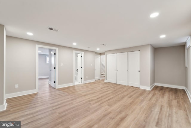 interior space with baseboards, visible vents, stairway, light wood-type flooring, and recessed lighting