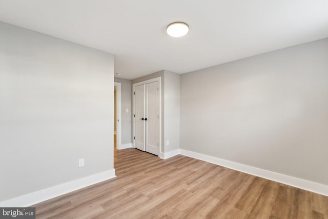 unfurnished room featuring light wood-type flooring and baseboards