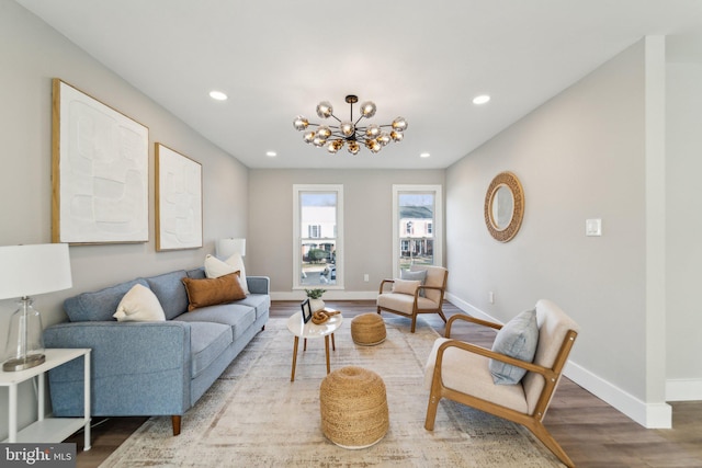 living room with baseboards, recessed lighting, wood finished floors, and an inviting chandelier