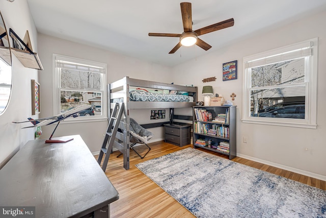 bedroom featuring ceiling fan, baseboards, and wood finished floors