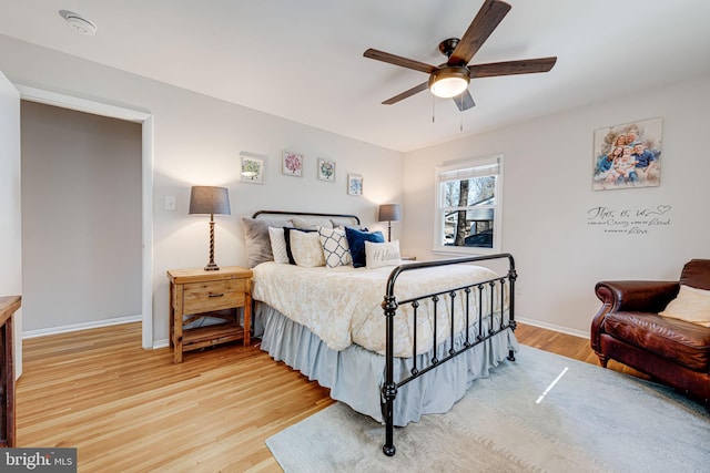 bedroom with ceiling fan, light wood-type flooring, and baseboards