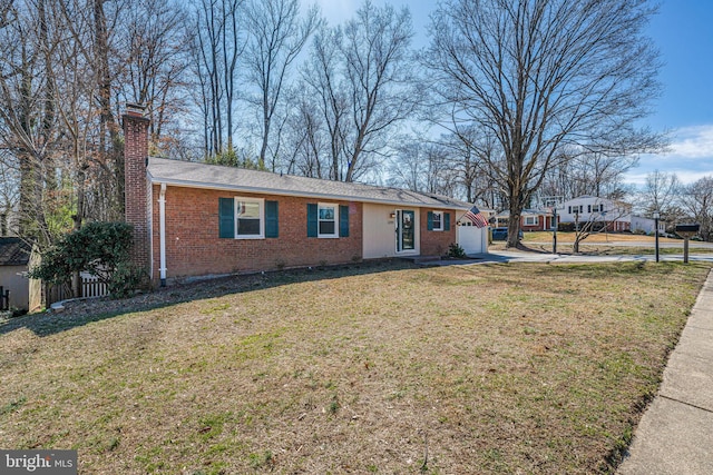 ranch-style home featuring brick siding, an attached garage, a chimney, and a front lawn