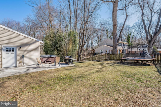 view of yard with a patio, a trampoline, fence, and a hot tub