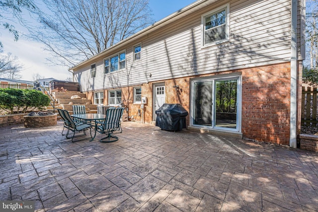 view of patio / terrace with a fire pit, fence, and grilling area