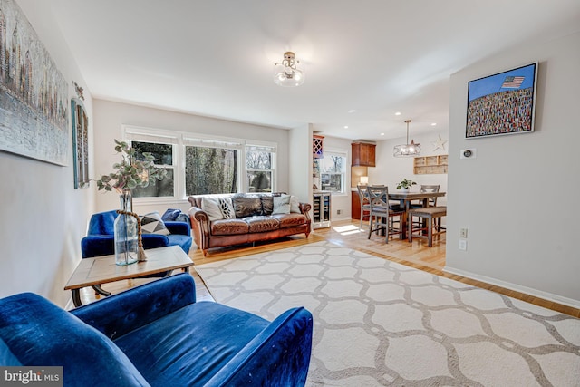 living room with light wood finished floors, beverage cooler, baseboards, and recessed lighting