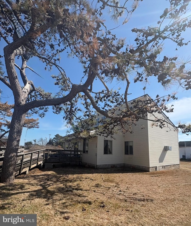 view of side of property with crawl space and fence