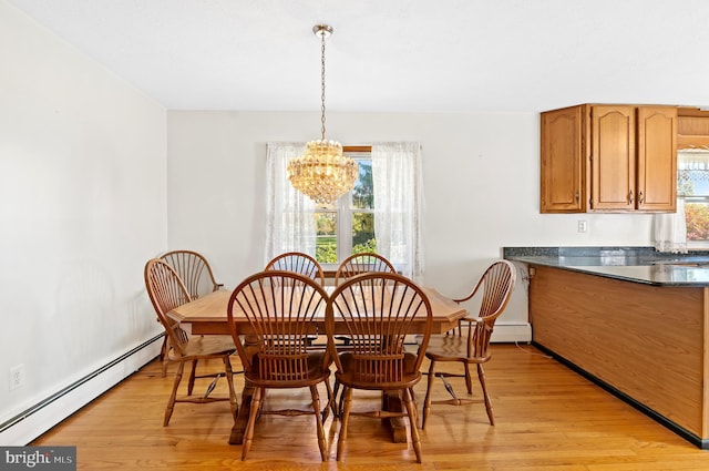 dining space featuring a baseboard heating unit, light wood finished floors, and an inviting chandelier