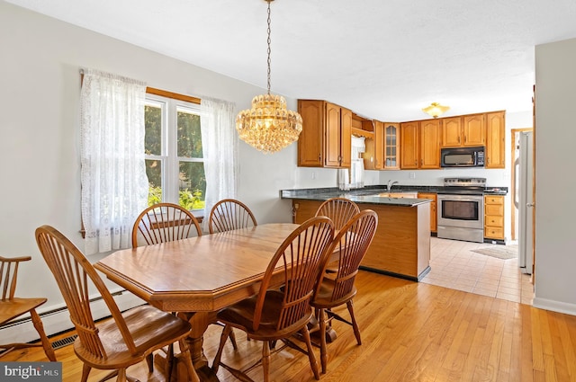 dining area with light wood-style flooring and an inviting chandelier