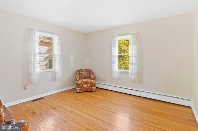 unfurnished room with light wood-type flooring, baseboards, visible vents, and baseboard heating