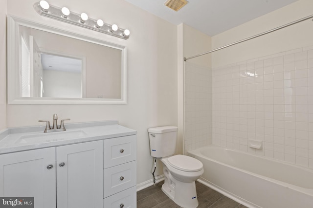 bathroom featuring visible vents, toilet, vanity, wood finished floors, and shower / bathtub combination