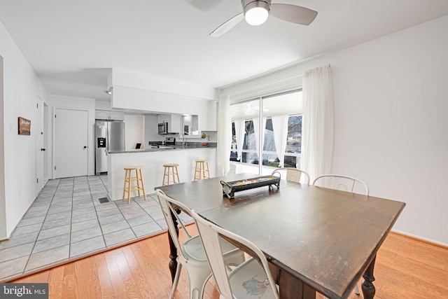 dining space featuring light wood-style flooring and ceiling fan