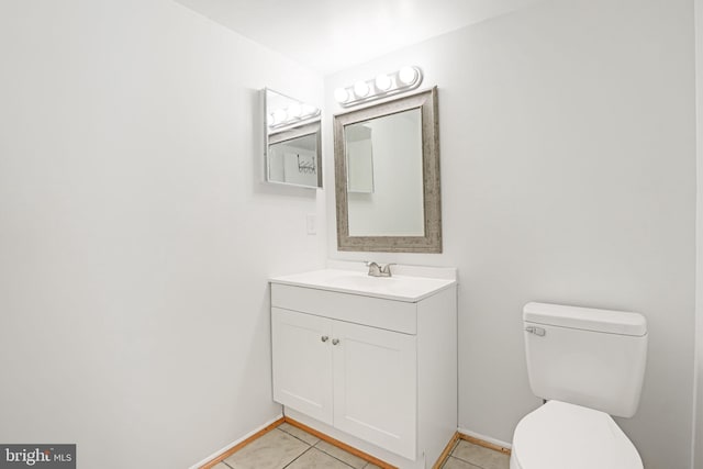 bathroom featuring vanity, tile patterned floors, toilet, and baseboards