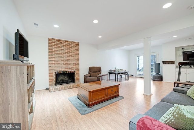 living area with recessed lighting, baseboards, light wood-style floors, and a fireplace