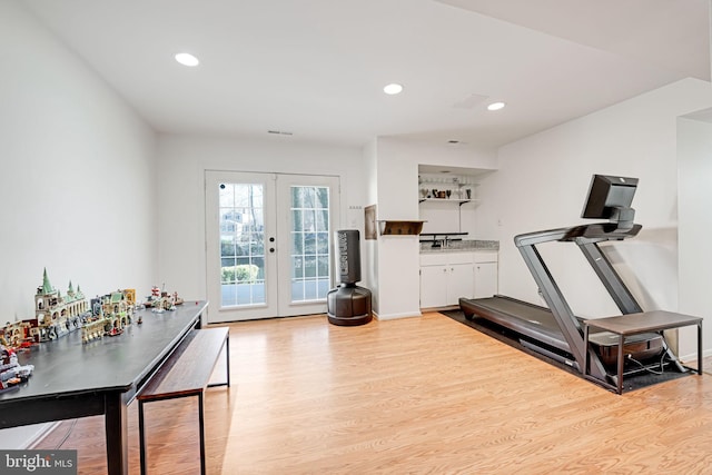 workout area featuring light wood-type flooring, visible vents, recessed lighting, french doors, and baseboards